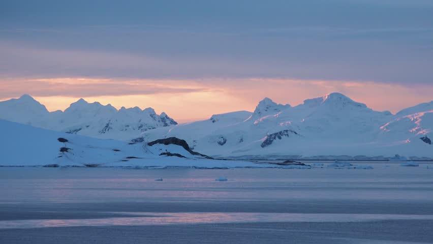 Ecology. Antarctica Nature. Polar ecosystem. Icebergs, snow-capped mountain range against blue cloudy sky. Magestic snow winter landscape. Exploring beauty world, holidays, recreation, travel concept.