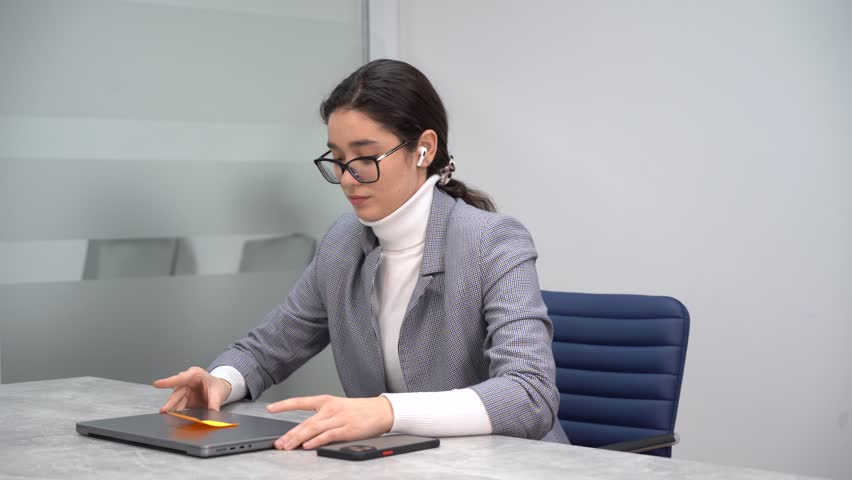Young female business manager, at the beginning of her working day, starting her laptop and feeling optimistic about her business project | Shutterstock HD Video #1099630829