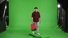 Caucasian Man With Shopping Bags Smile And Walking In Front Of Green Screen