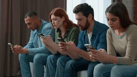 Millennial 30s diverse people sit in line on sofa holding smartphone ignoring friends chatting online in messenger mobile phone addicted women men internet overuse problem modern wireless tech usage  - Powered by Shutterstock - Get 15% off with code: PIKWIZARD15