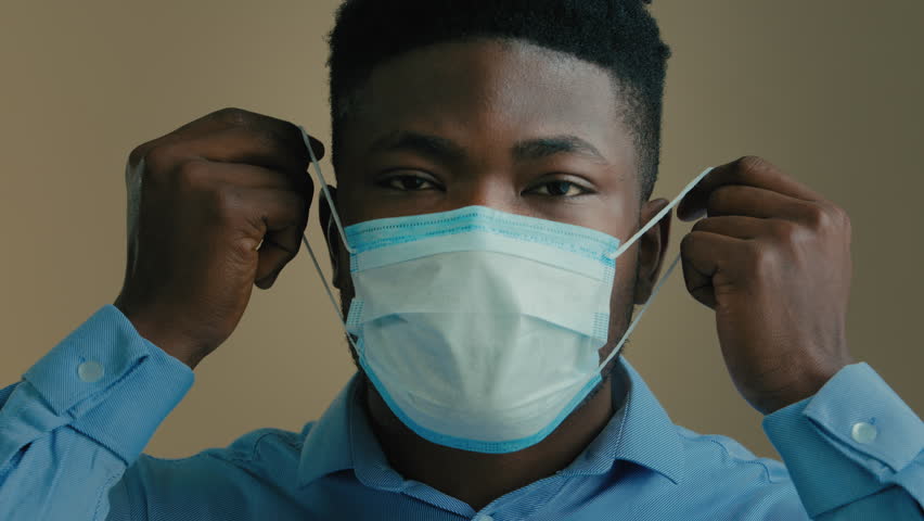 African American ethnic multiracial businessman adult man in medical mask indoors sick ill male patient office worker entrepreneur take off facial respirator inhale fresh air end of quarantine freedom | Shutterstock HD Video #1099633885