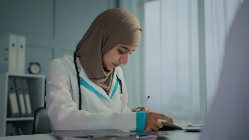 Woman doctor muslim arabian practitioner therapist general practitioner write notes medical insurance treatment recomedation female medic consult patient in clinic ask about health sickness symptoms Royalty-Free Stock Footage #1099633903