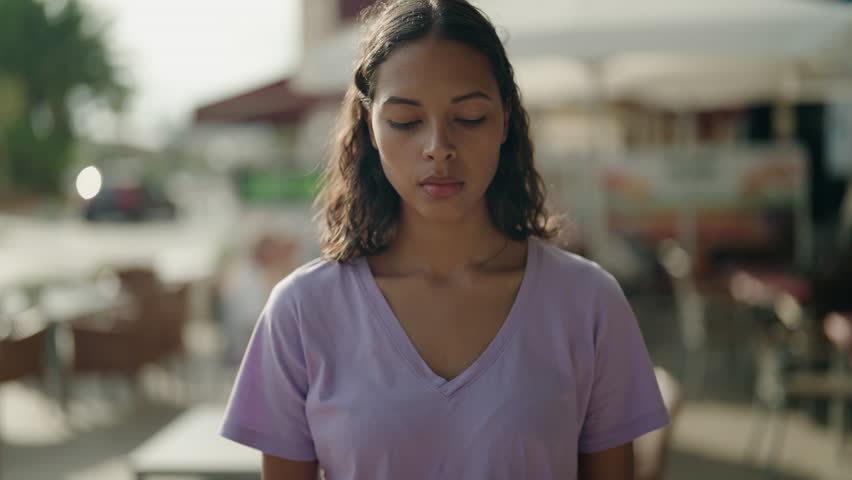 Young african american woman standing with serious expression at street