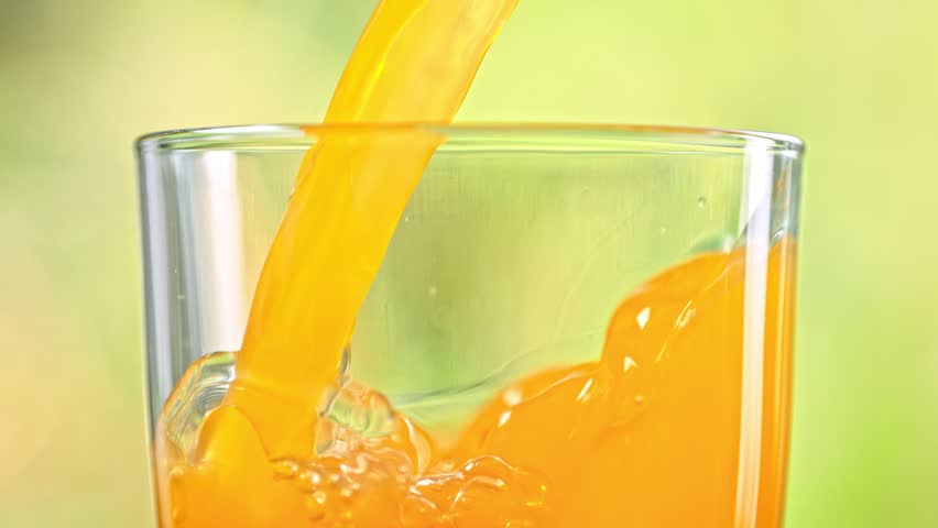 Super Slow Motion Detail Shot of Pouring Fresh Orange Juice into Glass at 1000 fps. Royalty-Free Stock Footage #1099634987
