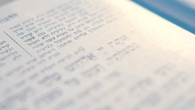 Close-up video recording of Hebrew words in the open Torah book.