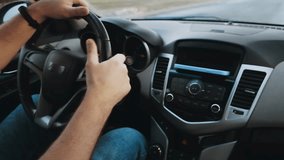 Hands of unrecognizable man driver using mobile phone while driving car, slow motion video