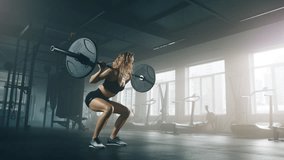 Close-up shot of a confident girl with curly, blonde hair doing squats with a barbell while exercising in the gym. Active, fit lady testing her strength with intensive workout. High quality 4k footage - Powered by Shutterstock - Get 15% off with code: PIKWIZARD15