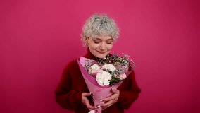 Portrait of blonde-haired girlfriend receiving beautiful flowers. Close-up view of a smiling, charming woman enjoying Valentine's gift. High quality 4k footage - Powered by Shutterstock - Get 15% off with code: PIKWIZARD15
