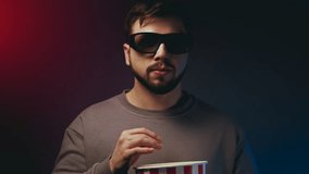 A man with popcorn is watching a 3D movie. High quality 4k footage