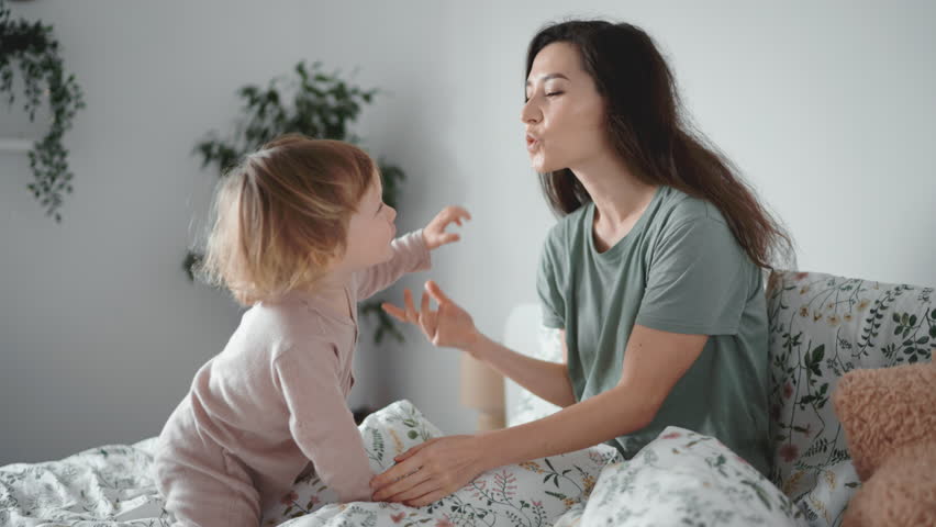 young asian mother kiss and play with her curly toddler son in morning bedroom. Concept of children, baby, parenthood, childhood, life, maternity, motherhood relationship Authentic close up shot of Royalty-Free Stock Footage #1099653899