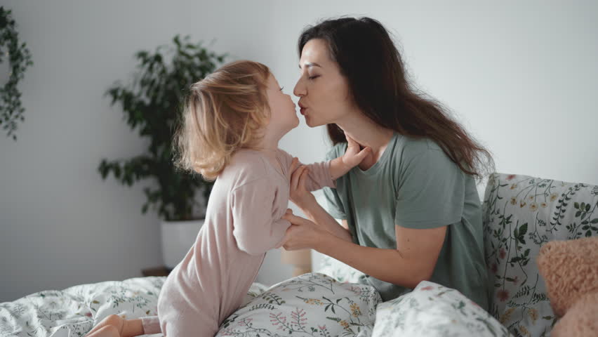 Young asian mother kiss and play with her curly toddler son in morning bedroom. Concept of children, baby, parenthood, childhood, life, maternity, motherhood relationship Authentic close up shot of | Shutterstock HD Video #1099653899