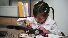 Asian littlle girl constructing and coding robot at STEM class,Fixing and repair mechanic toy car - Powered by Shutterstock - Get 15% off with code: PIKWIZARD15