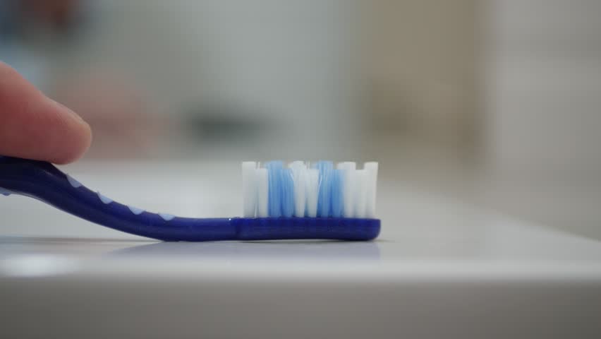 Close-Up Shooting with a Person in the Bathroom Putting Toothpaste on a Toothbrush. Daily and Healthy Routine for Tooth Cleaning. | Shutterstock HD Video #1099658195