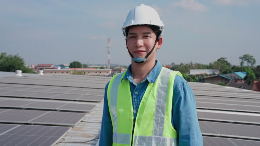 Portrait shot of Asian solar engineer man smiling at the rooftop and Looking at camera | Shutterstock HD Video #1099659373