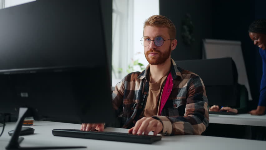 Front-end web developer working in office, sitting at table with computer, portrait, data scientist | Shutterstock HD Video #1099661891
