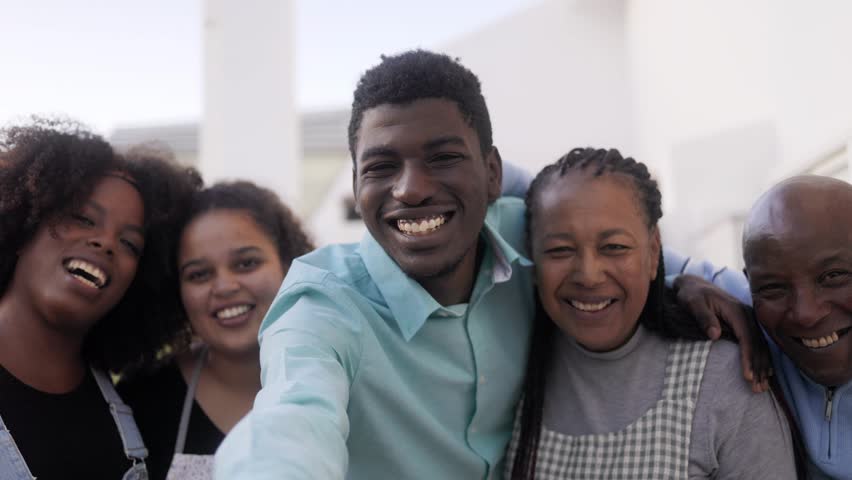 Happy African family doing video call outdoor at home terrace