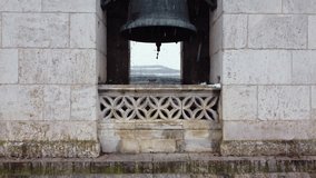 Close up of a bell on bell tower on top of an ancient church on a snow day in Spain. High quality 4k footage