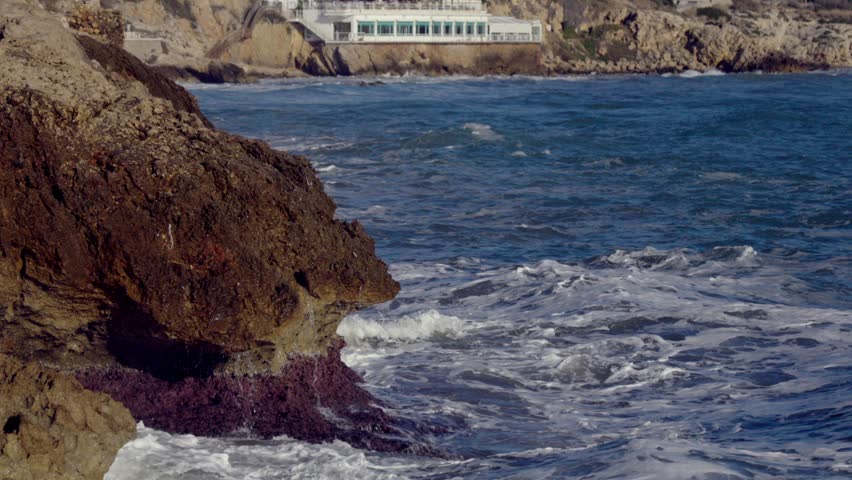 Big waves crash against the rocky shore