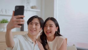 Young couple making selfie communicates with parents via video call. Phone conversation. Asian lover family talking video calling from new home. Happy distance friends chatting online in virtual app.