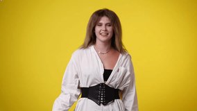 4k video of girl dancing on yellow background.