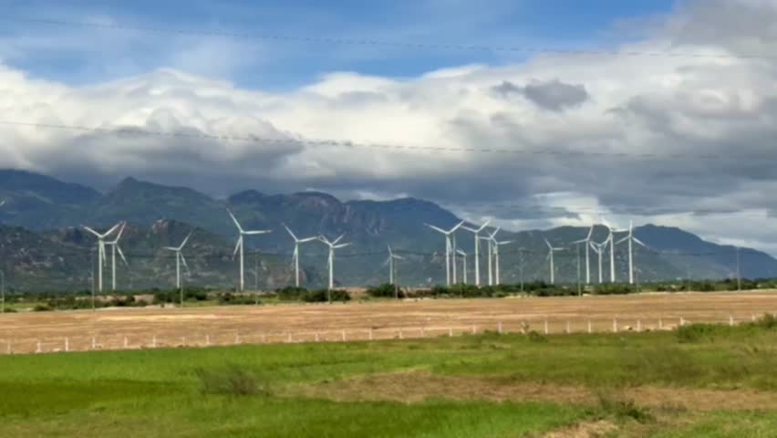Windmills for electric power production in Vietnam. Wind turbines farm, windmill farm producing green energy on natural background. Renewable Energy concept, technology landscape  | Shutterstock HD Video #1099677613