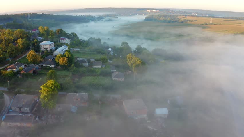 4k drone flight back footage (Ultra High Definition) of foggy Ukrainian countryside. Nice morning view fron flying drone of misty village, Ternopil, Ukraine. Beauty of countryside concept background.
