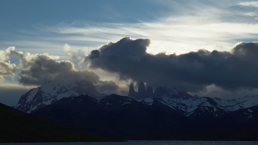 Thick clouds moving over the iconic Torres of Torres del Paine national park along the andes mountains in Patagonia, Chile