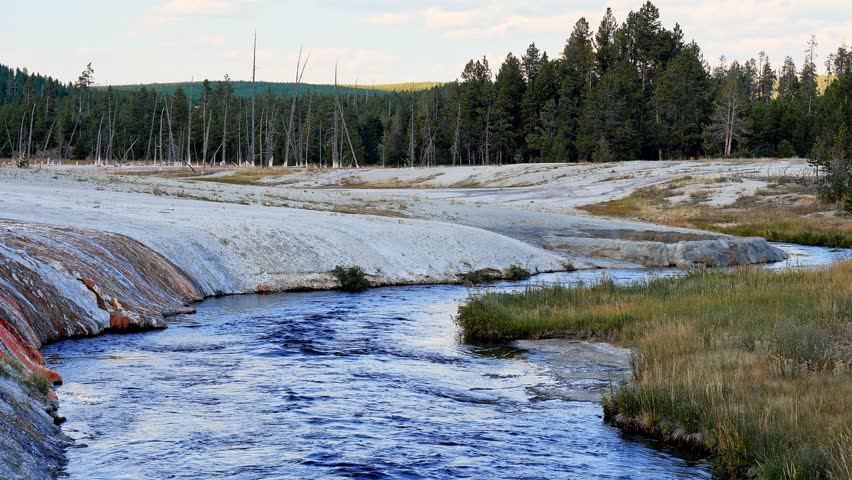 Beautiful view of hot spring pool geothermal landscape. Geyser basin and forest. Famous tourist attraction at Yellowstone national park. Hot thermal spring Black Pool in Yellowstone National Park