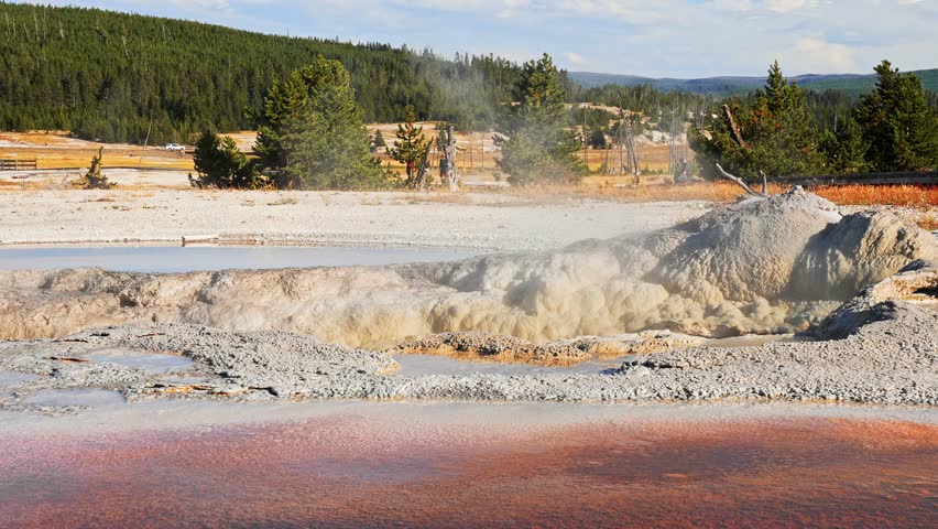 Beautiful view of hot spring pool geothermal landscape. Geyser basin and forest. Famous tourist attraction at Yellowstone national park. Hot thermal spring Black Pool in Yellowstone National Park