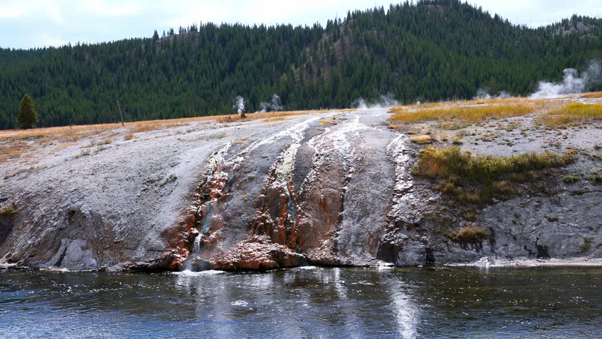 Beautiful view of hot spring pool geothermal landscape. Geyser basin and forest. Famous tourist attraction at Yellowstone national park. Hot thermal spring Black Pool in Yellowstone National Park