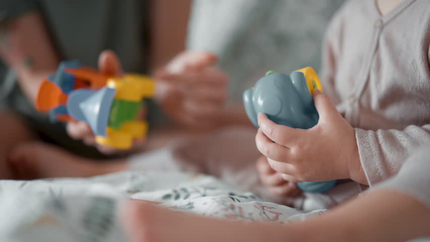 close up shot details of mother play toy cars with her toddler son baby in morning bedroom. Concept of children, baby, parenthood, childhood, life, maternity, motherhood relationship. Faceless frame Royalty-Free Stock Footage #1099684015