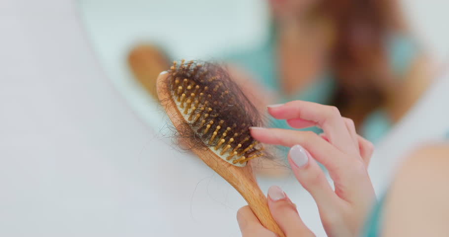 closeup hairbrush - asian worried woman standing in front of mirror has hair loss problem