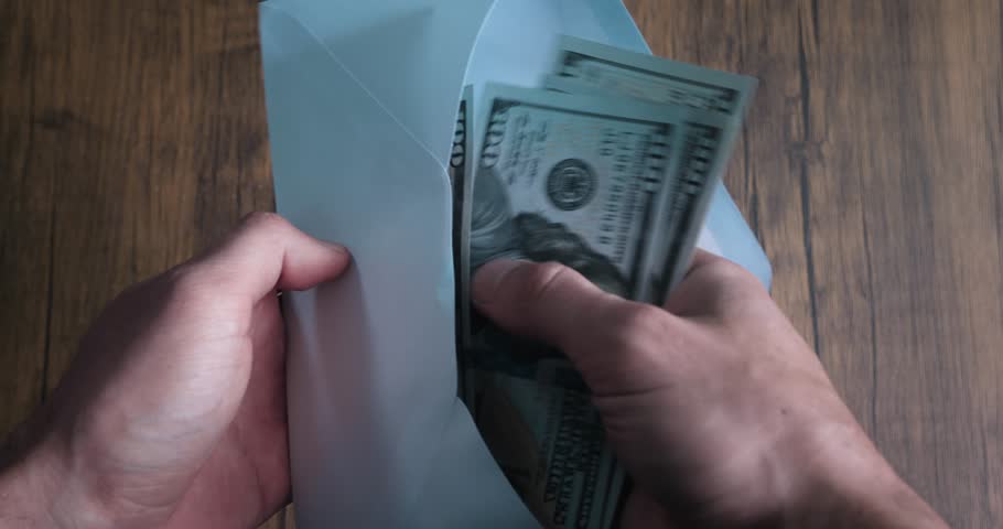 Close up business person takes envelope with dirty money. Male Counting hundred dollar banknotes from envelope. Salary in an envelope for tax evasion. Illegal business deal with cash money | Shutterstock HD Video #1099694159