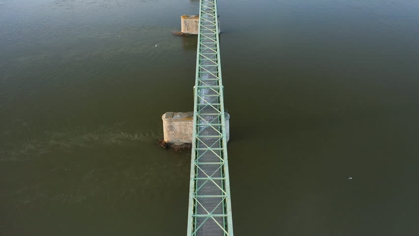 An old steel bridge over the Loire in Europe, in France, in the Center region, in the Loiret, in Sully sur Loire, in Winter, on a sunny day.