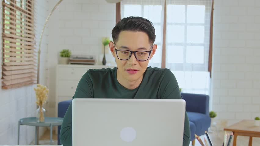 Young asian businessman excited and thrilled with the business success while working at home. | Shutterstock HD Video #1099700063