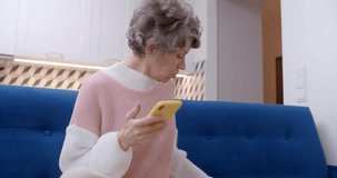 Elderly lady turns on a TV and gets happy and exited, 4k
