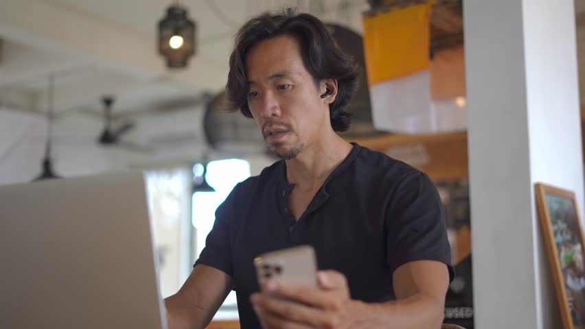 Asian freelancer online sit work job cafe. Busy people talk video link conference. Boss person use cell mobile phone meeting call covid-19. Guy user iphon chat Asia. Man start up airpoding headphones.