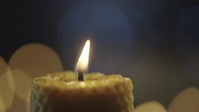 Macro video of a candle burning and extinguishing in the dark. Background video. Beautiful romantic atmosphere with candles. High quality 4k footage