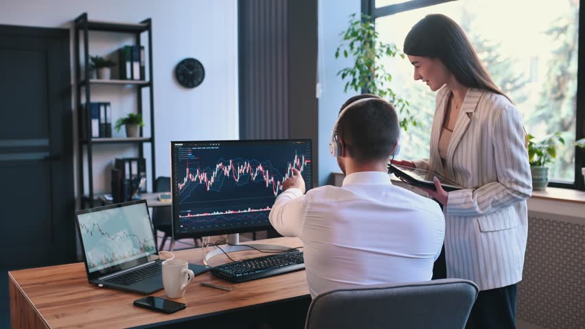 Analyzing the graphs. Man and woman are working together by computer in the office. Conception of exchange. Royalty-Free Stock Footage #1099716309