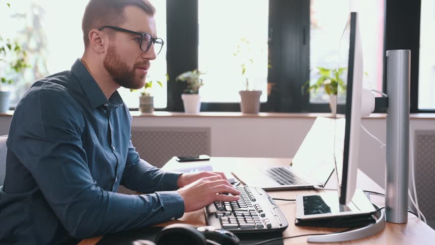 Programmer is working in the modern office. Sitting by computer. Royalty-Free Stock Footage #1099717079