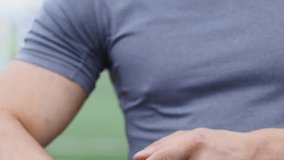 Athlete checks his performance on the fitness bracelet after training. Close-up on a man's hand modern smart watch with black strap