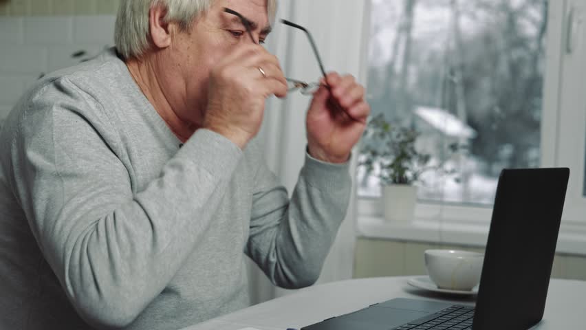 Busy Tired Old Man Using Laptop working from home. Manager Rests His Eyes and thinking over retirement. Stressed Older Man Solving Solutions. Aged male in eyeglasses feeling depressed and exhausted. | Shutterstock HD Video #1099721591