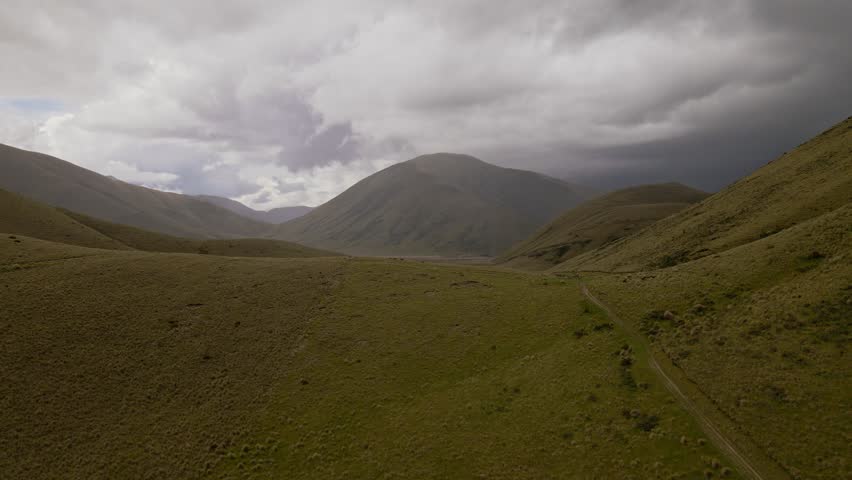 Dark, heavy clouds low over lush, mountainous landscape in New Zealand