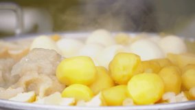Potatoes, Tofu and Eggs steaming in a steam pot. Visible steam from steamed food - Indonesian street food named Siomay