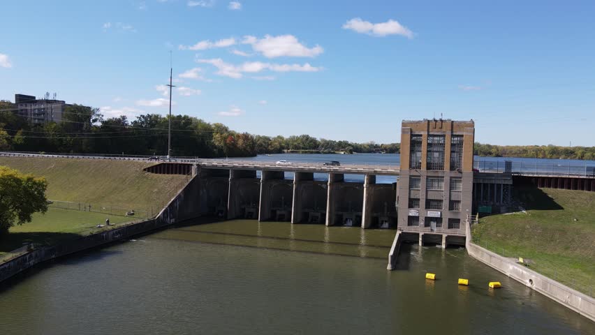 Cars driving over Ypsilanti water dam on sunny day, aerial drone view