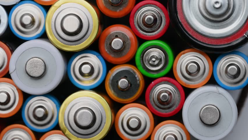 Different batteries close-up rotating on a turntable, top view. Background of colorful batteries.The concept of hazardous waste, disposal of used batteries, ecology. | Shutterstock HD Video #1099723463