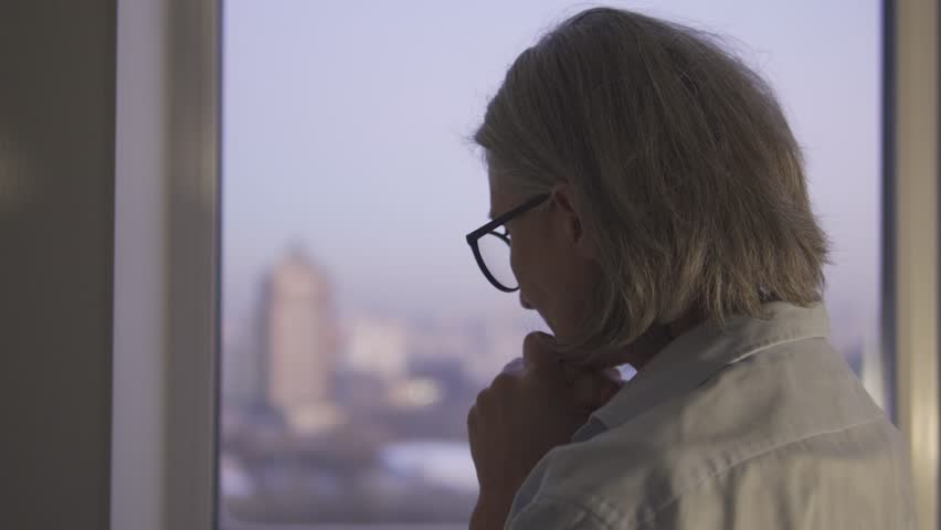 Female doctor looking at window with sadness, caring for a seriously ill patient | Shutterstock HD Video #1099725287
