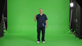 Male doctor swipes finger at display of like a phone. Man over green screen background, Chroma Key. 4k video footage
