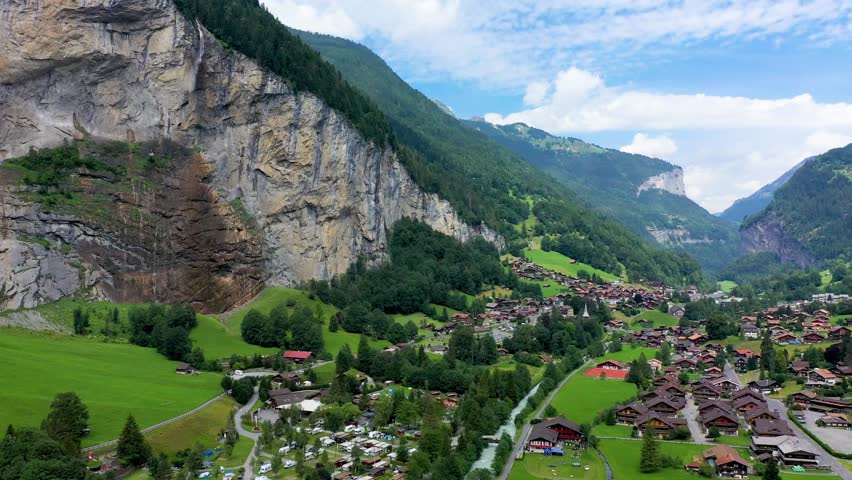 Lauterbrunnen valley with famous church and Staubbach waterfall. Lauterbrunnen village, Berner Oberland, Switzerland, Europe. Spectacular view of Lauterbrunnen valley in a sunny day, Switzerland. Royalty-Free Stock Footage #1099730617