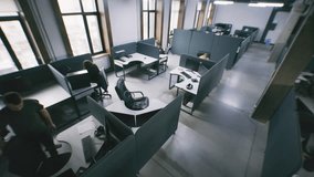Security camera view of people working at office with modern design and sitting at the tables with computers. Woman comes to colleague and helps with project task. IT company. Concept of coworking. - Powered by Shutterstock - Get 15% off with code: PIKWIZARD15